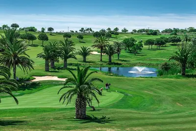 a golf course with palm trees and a pond at Luz casas- 44 Fairview village Boavista in Lagos