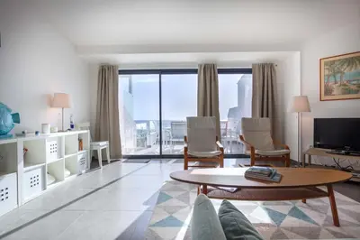 a living room with a table and chairs and a large window at Beco Do Poço in Luz
