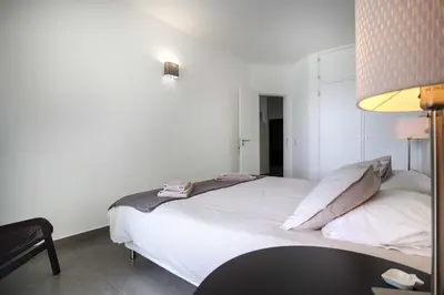 a white bed in a room with a lamp at Beco Do Poço in Luz