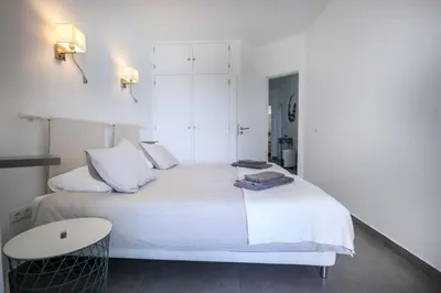 a white bedroom with a white bed and a table at Beco Do Poço in Luz