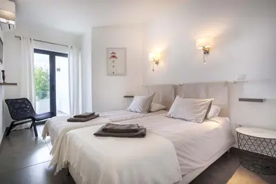 a bedroom with two beds with towels on them at Beco Do Poço in Luz