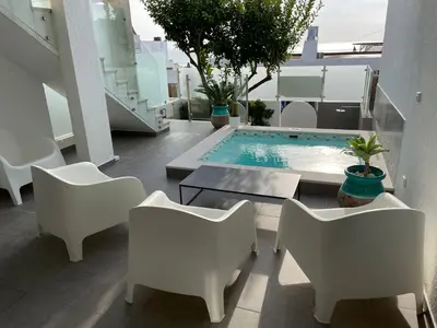 a balcony with white chairs and a swimming pool at Beco Do Poço in Luz
