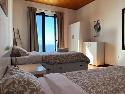 a bedroom with a bed with a view of the ocean at Casa Vista do Ledo in Arco da Calheta