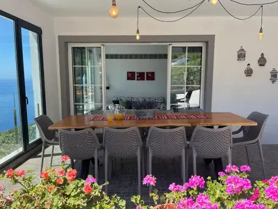 a living room with two chairs and a table at Casa Vista do Ledo in Arco da Calheta