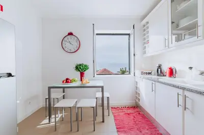 a kitchen with a table and a clock on the wall at Funchal Old Town Apartments 2.8 in Funchal