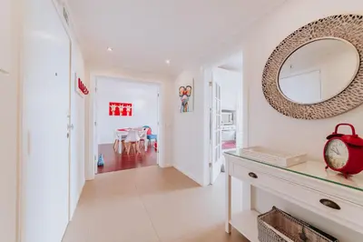 a white hallway with a mirror and a table at Funchal Old Town Apartments 2.8 in Funchal