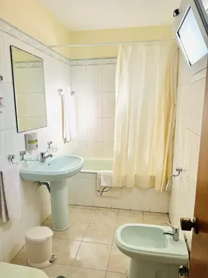 a bathroom with a sink and a toilet and a mirror at Residencial Santo António in Santa Cruz