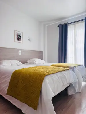 a bedroom with a large bed with a yellow blanket at Residencial Santo António in Santa Cruz