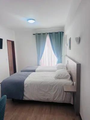 a bedroom with a large bed and a window at Residencial Santo António in Santa Cruz
