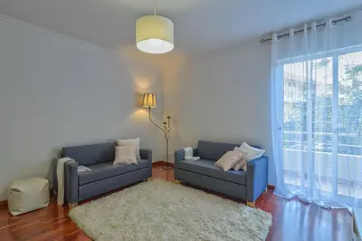 a living room with two blue couches and a large window at Golden Place Apartment in Funchal