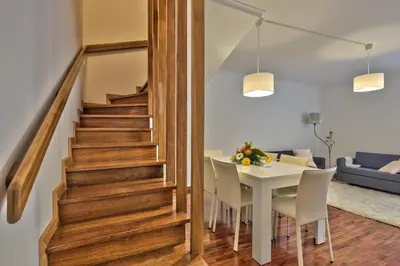 a stairway leading to a dining room and living room with a table at Golden Place Apartment in Funchal