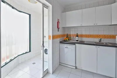 a kitchen with white cabinets and a sink at Golden Place Apartment in Funchal