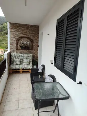 a patio with chairs and a couch on a balcony at Marques House in Machico