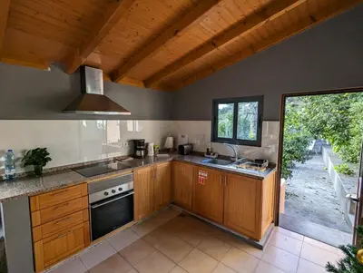 a kitchen with wooden cabinets and a stove top oven at Casa do Avo in Arco da Calheta