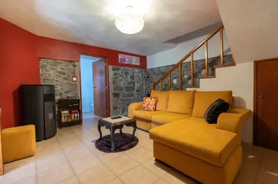 a living room with a couch and a tv at Casa do Avo in Arco da Calheta