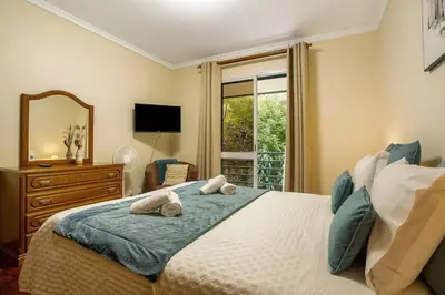 a bedroom with a bed with a mirror and a window at Madeira Funchal Gardens in Funchal