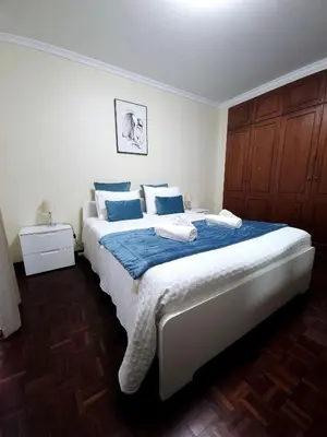 a bedroom with a large bed with blue pillows at Madeira Funchal Gardens in Funchal