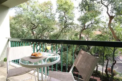 a table and chairs on a balcony with a view of trees at Flat with Balcony at Downtown by Farmers Market in Funchal