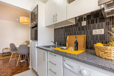 a kitchen with white cabinets and a counter top at Flat with Balcony at Downtown by Farmers Market in Funchal