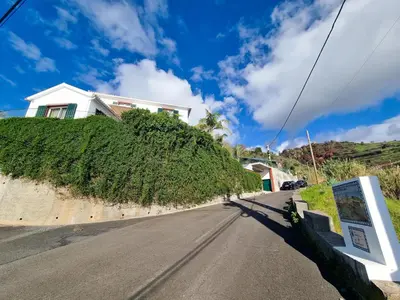 a house on a hill next to a road at Casa da Ladeira in Fajã da Ovelha