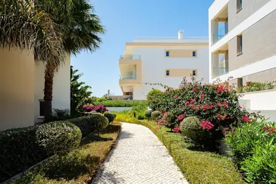 a walkway in front of a building with flowers at Porto de Mos Golf & Beach B&B AL-40312 in Lagos