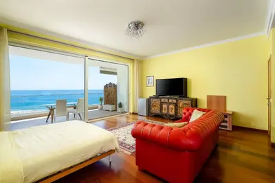 a living room with a red couch and a large window at Porto de Mos Golf & Beach B&B AL-40312 in Lagos