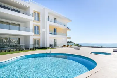 a villa with a swimming pool in front of a building at Porto de Mos Golf & Beach B&B AL-40312 in Lagos