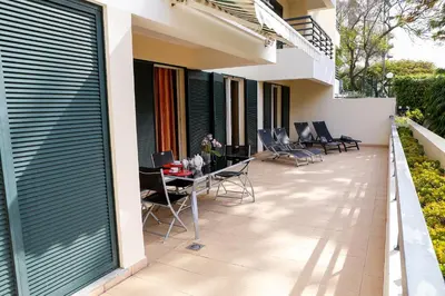 a balcony with chairs and tables on a house at Apartamento Infante in Funchal