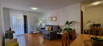 a living room with a blue couch and a table at Apartamento Infante in Funchal