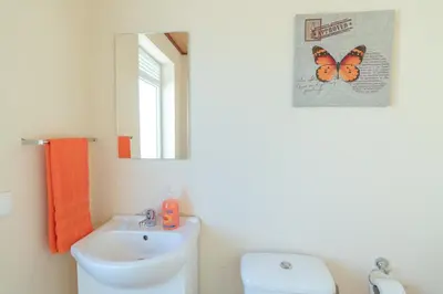 a bathroom with a sink and a butterfly picture on the wall at Casa Sol e Vista in Arco da Calheta