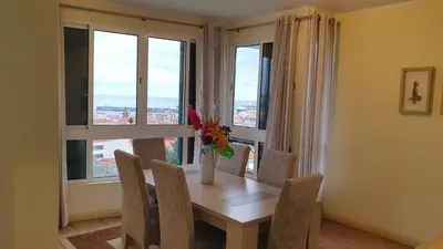 a dining room with a table and chairs and windows at Funchal Apartament Marina View with PARKING FREE in Funchal