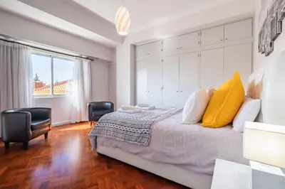 a bedroom with a large bed with yellow pillows at Apartamento Jasmineiro - By WeHost in Funchal