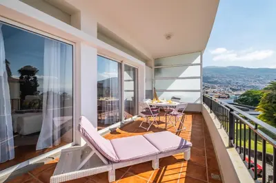 a balcony with a table and chairs and a view at Apartamento Jasmineiro - By WeHost in Funchal