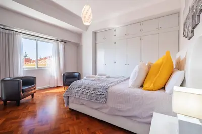 a bedroom with a king sized bed with yellow pillows at Apartamento Jasmineiro - By WeHost in Funchal