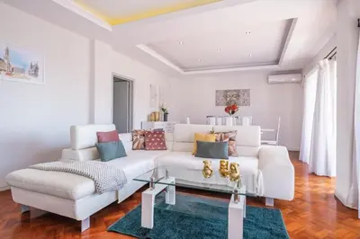 a living room with a white couch and a table at Apartamento Jasmineiro - By WeHost in Funchal