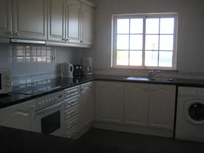 a kitchen with white cabinets and a sink and a window at GUADALUPE 3 in Luz