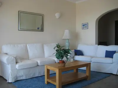 a living room with a white couch and a table at GUADALUPE 3 in Luz