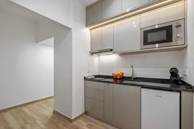 a kitchen with white cabinets and a microwave at Navio Azul Apartment in Funchal