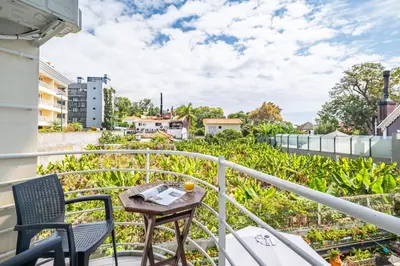 a balcony with a table and chairs on a building at Navio Azul Apartment in Funchal