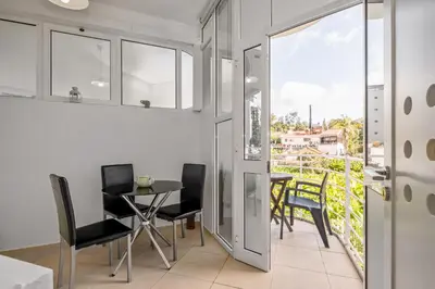 a dining room with a table and chairs and a balcony at Navio Azul Apartment in Funchal