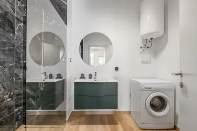 a bathroom with a sink and a washing machine at Navio Azul Apartment in Funchal