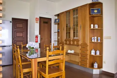 a dining room with a wooden table and chairs at Quinta Tallinus in Funchal