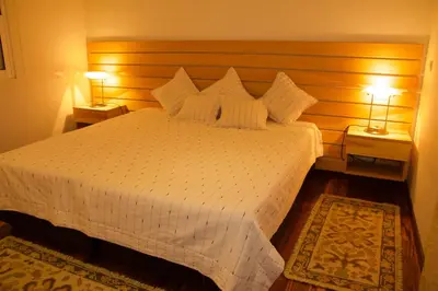 a bedroom with a large white bed with two lamps at Quinta Tallinus in Funchal