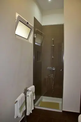 a bathroom with a shower with a glass door at Quinta Tallinus in Funchal