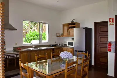 a kitchen with a glass table and a refrigerator at Quinta Tallinus in Funchal