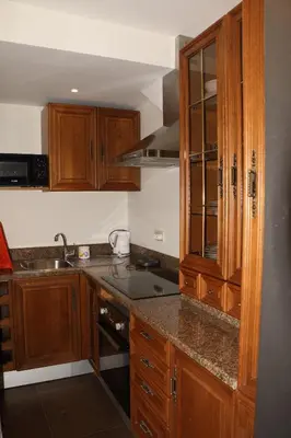 a kitchen with wooden cabinets and a counter top at Quinta Tallinus in Funchal