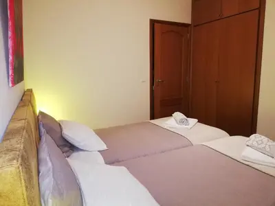 two twin beds in a room with a door at Imaculado Village in Funchal