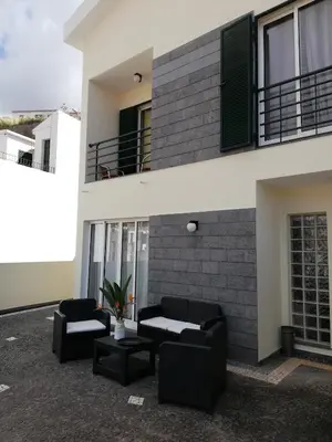 a building with two black couches and a balcony at Imaculado Village in Funchal