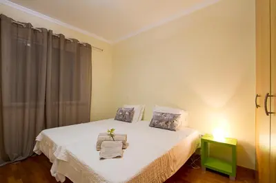a bedroom with a bed with a green end table at Apartamento do Avô Tomás in Madalena do Mar