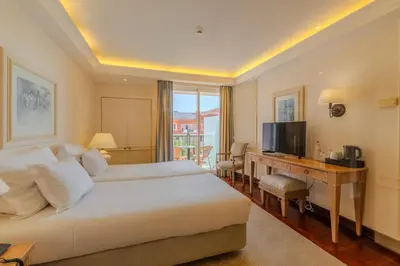 a bedroom with a bed and a desk and a television at Pestana Royal All Inclusive Ocean & Spa Resort in Funchal